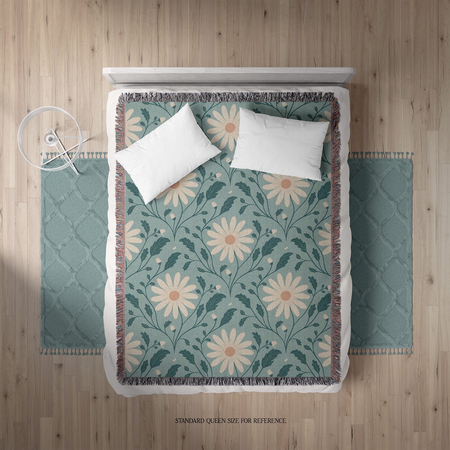 Floral patterned throw blanket on a bed with white pillows.